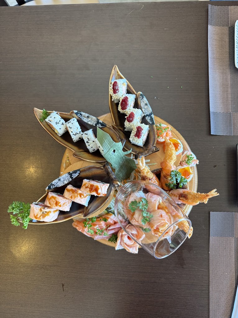 Combinado servido em suportes de madeira e cerâmica, com sashimi, makis e tempura de camarão