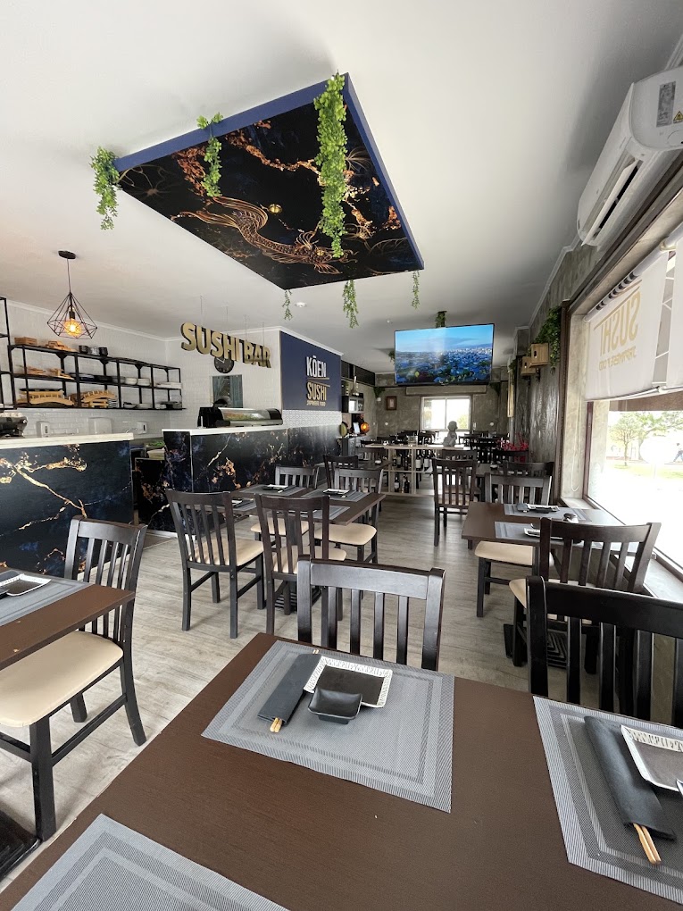 Sala do Koen Sushi durante o dia, com o balcão do sushi bar e mesas postas