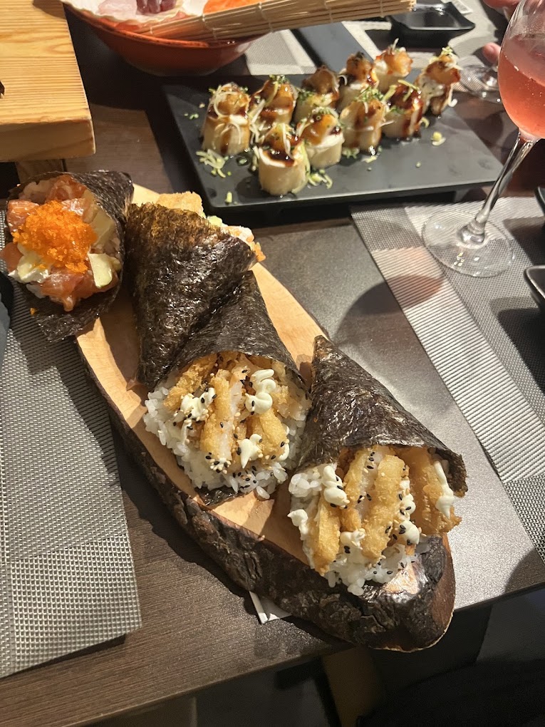 Temakis de camarão crocante e gunkan de salmão sobre tábua de madeira, no Koen Sushi