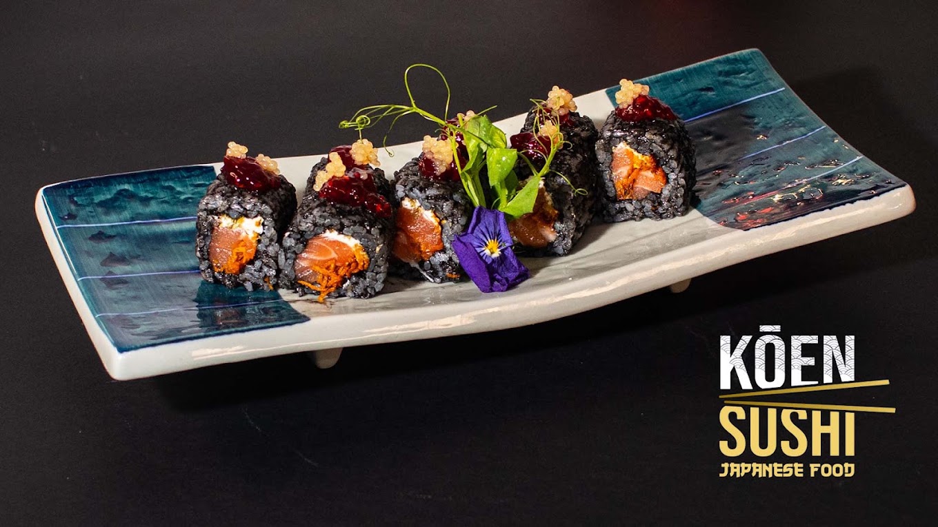 Cinco makis de arroz preto com salmão numa travessa de cerâmica azul e branca do Koen Sushi